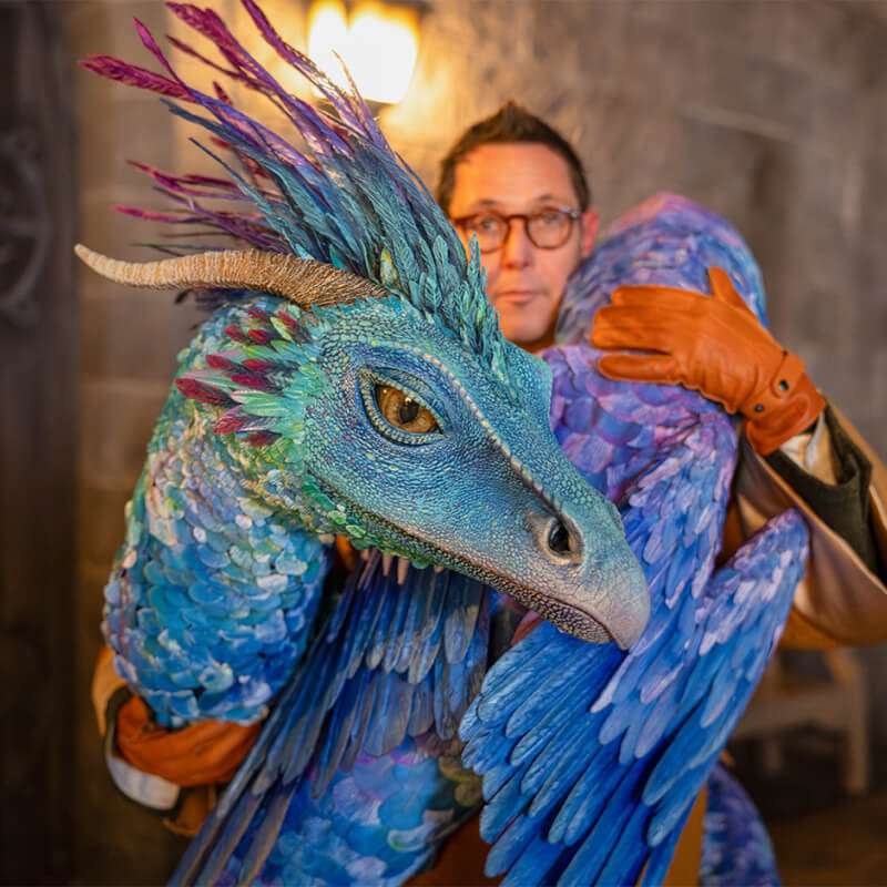 A person holding a large replica of Occamy.
